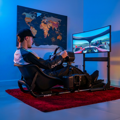 Driver using NitroKart cockpit with dual monitor stand setup, gaming room lifestyle photo